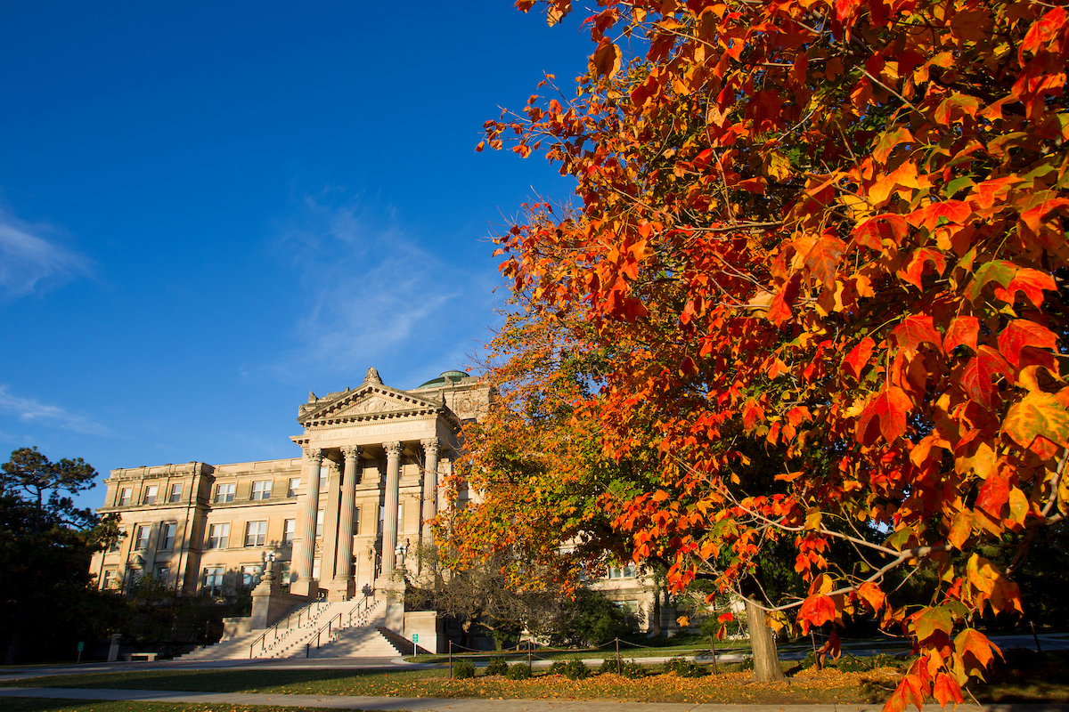 Image shows Beardshear Hall with orange and yellow fall colors in the trees.