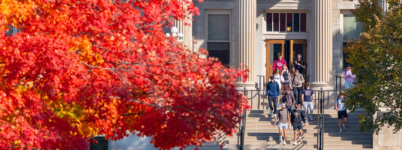 Fall view of students walking in and out of Curtiss Hall.